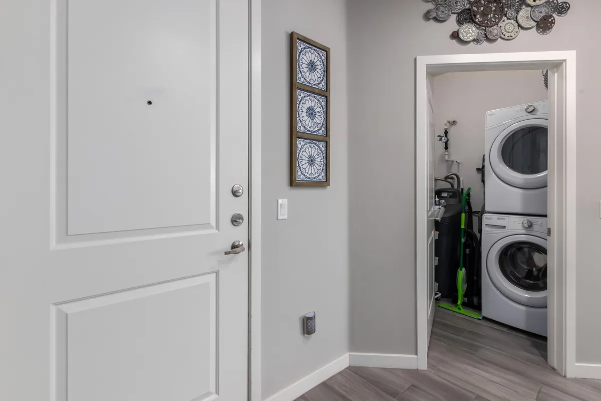 A well-organized laundry area near the front door, featuring a full-size washer and dryer and decorative wall art. The space is both functional and aesthetically pleasing, offering convenience for longer stays.