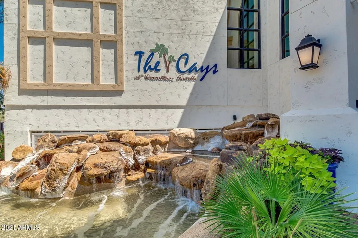 A tranquil outdoor scene with a water feature, tasteful signage, and manicured landscaping. The setting offers a sense of calm and sophistication, making it an inviting space for peaceful strolls or quiet moments on arrival.